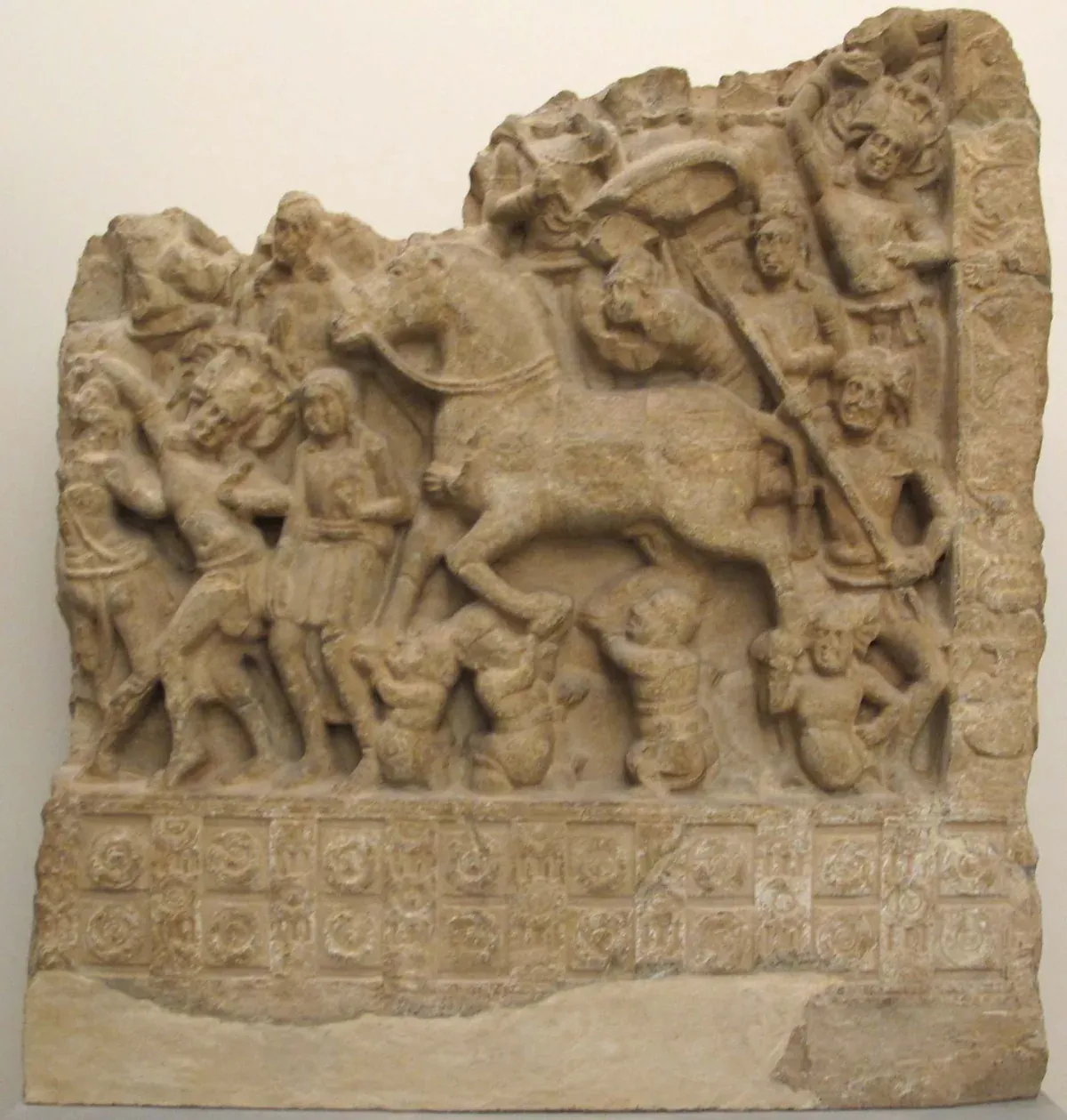 पत्थर की पट्टिका पर उकेरा दृश्य: बिना सवार का घोड़ा, ऊपर छत्र और आसपास लोग
