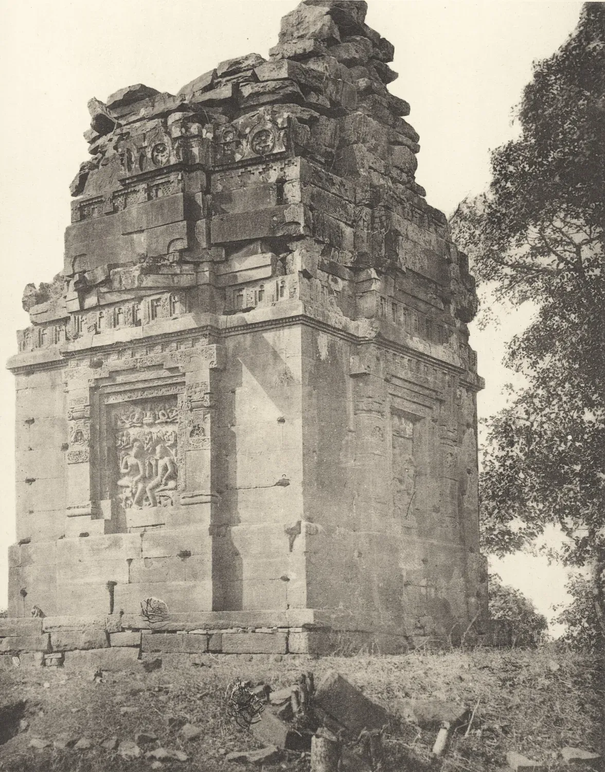 1897 का श्वेत-श्याम छायाचित्र: ऊँचे चबूतरे पर पत्थर का छोटा मंदिर, ऊपर टूटा शिखर
